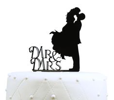 a cake topper with the silhouette of a man and woman holding each other in their arms