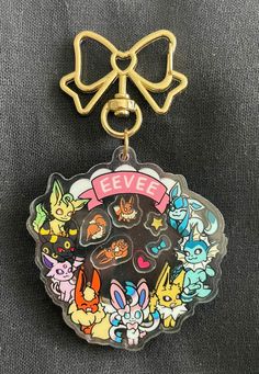 a keychain with an image of several cartoon characters and the words eevee on it