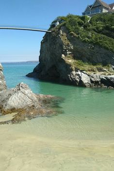 a bridge that is over the water near some rocks