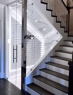 an open door leading up to a stair case in a white house with wood floors