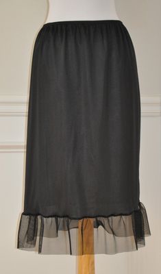 "An exquisite accessory for your wardrobe, this underskirt slip worn with your skirt or dress will make you feel very special ! It is made of black nylon with elastic waistband and black tulle ruffle trim 7\" long. Standard length is 25\" This accessory makes a perfect gift! Hand wash in cold water. Available in sizes: XS-0-2, Waist: 24 1/2\", Hip: 35\" S-4-6, Waist: 25 1/2\"-26 1/2\", Hip: 36-37\" M-8-10, Waist: 27 1/2-28 1/2\", Hip: 38-39\" L-12-14, Waist: 30-31 1/2\", Hip: 40 1/2-42\" XL-16-1 Black Lace Trim Bottoms For Evening, Evening Black Bottoms With Lace Trim, Elegant Black Sheer Bottoms, Elegant Black Bottoms With Lace Trim, Elegant Lace Trim Evening Bottoms, Elegant Evening Bottoms With Lace Trim, Formal Long Sheer Skirt, Elegant Relaxed Skirt With Ruffles, Lace Trim Skirt For Evening