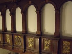 an old wooden wall with ornate carvings on the sides and gold leaf designs on the panels