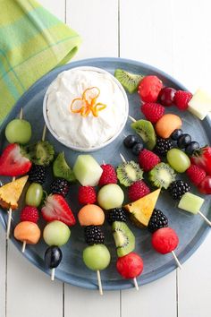 fruit skewers are arranged on a blue plate