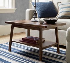 a coffee table with books on it in front of a couch