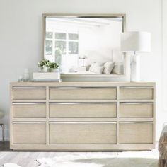 a bedroom with a dresser and mirror in it