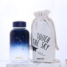 a bottle and bag sitting next to each other on a white surface with the words touch the sky