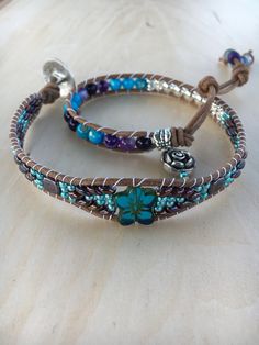 Silver Turquoise, Agate, Flower, Hematite Leather Double Wrap Bracelet This Bracelet Features.... Genuine Natural color Round Leather 2mm Beautiful 6mm Turquoise Shell Beads  6mm Purple Agate Beads with such colorful designs 6mm Hematite Beads Superduos(2 hole) beads 14 mm Glass Flower Bead 2 square purple tile beads Silver Edelwiss Flower Button 20mm This Bracelets has 12" of beading with 2 button hole type adjustments at 13 1/2" and 15" and wraps around your wrist twice. The length listed is the inside circumference when the bracelet is clasped. This bracelet will fit a size 6 1/2"-7" wrist comfortably. Agate transforms negativity into positivity. Agate enhances mental function and improves concentration. Agate is a protection and good luck stone, helps balance, and gives us strength to Agate Beaded Bracelets, Purple Tile, Wrap Armband, Jewelry Making Business, Stone Bead Jewelry, Purple Wrap, Bracelet Craft Diy, Super Duo, Flower Button