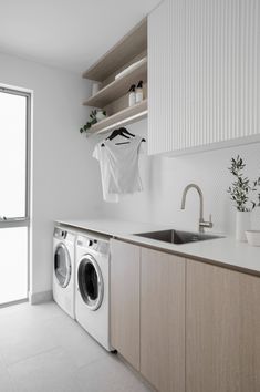 a washer and dryer sitting in a kitchen next to an open sink window