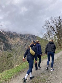 two women walking down a trail in the mountains