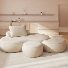 a large white couch sitting in a living room next to a table and dresser on top of a hard wood floor