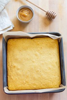 a pan filled with batter next to a cup of honey