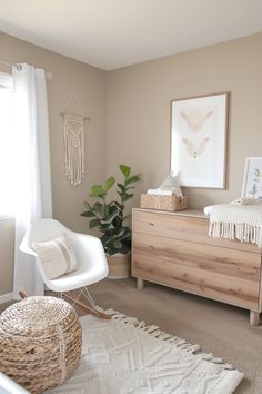 a baby's room with a crib, dresser and chair