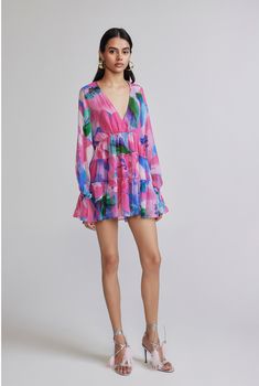 The Vesa Multi Coloured Short Dress from the Resort'24 collection is a vibrantly chic addition to your vacay wardrobe. Crafted from flowy viscose crinkle chiffon, the V-neck and voluminous Bishop sleeves add a hint of chic sophistication while the crisscross back tie-up injects some playful drama. The dress boasts a tiered hemline that rests above the knees and an eye-catching abstract print that makes the dress the perfect choice for a stylish getaway. Made In India Multi Colour Abstract Print Flowy Floral Print V-neck Dress, Flowy V-neck Chiffon Dress For Summer, Chic V-neck Chiffon Beach Dress, Chic Multicolor Chiffon Beach Dress, Chic Pink V-neck Dress For Vacation, Summer Pink V-neck Cocktail Dress, Pink V-neck Summer Cocktail Dress, Pink V-neck Cocktail Dress For Summer, Multicolor Floral Print Chiffon Dress V-neck