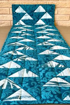 a blue quilt with white triangles on it