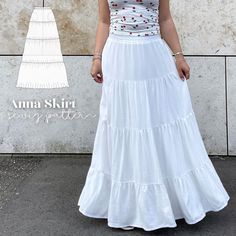 a woman standing in front of a wall wearing a white dress