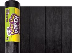 a roll of black paper sitting on top of a wooden floor