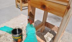 a paint can is sitting on the ground next to a wooden chair and some buckets