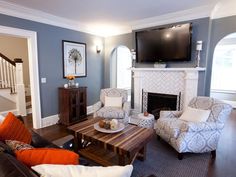 a living room filled with furniture and a flat screen tv mounted on the wall above a fireplace