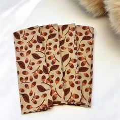 four napkins with brown leaves on them