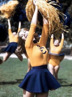 a group of cheerleaders in yellow shirts and blue skirts are holding up their pom poms