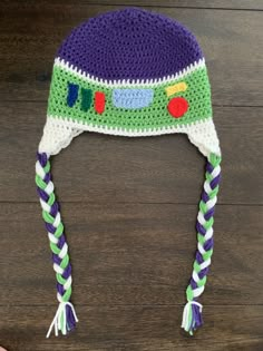 a child's crocheted hat with braids and a toy truck on it