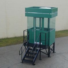 a small green cart sitting on the side of a road