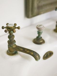 two faucets are sitting on the sink in front of some other faucets