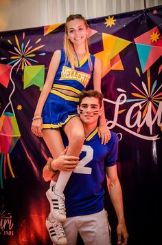 a man and woman posing for a photo in front of a banner