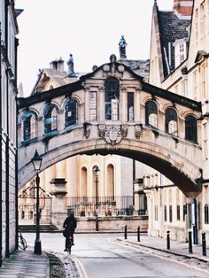 a person riding a bike under an arched bridge