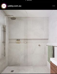 a bathroom with white walls and tile flooring next to a bathtub, shower head, and sink