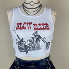 "Ribbed tank with a Slow Ride handpressed graphic inspired by 70's & 80's bikers. All tanks will have a cut hem. If you want it v-neck notch or tank to be extra shredded, let us know and we'll add holes, tears, wear marks etc... Want it cropped? Leave us a note! Available in unisex xs-xxl. Chest Measurements : XS (boys XL) - 32\"- 34\" S - 34\"- 36\" M - 38\" - 40\" L - 42\" - 44\" XL - 46\" - 48\" XXL - 50\" - 52\" Stay up to date on new items by following us on Instagram: @shophothoney ------ Retro Fitted Tank Top, Vintage Graphic Print Crop Top, White Grunge Tank Top With Graphic Print, Vintage Sleeveless Tank Top With Graphic Print, Retro Graphic Print Tank Top, Biker Chick Style, Clothes Beach, Motorcycle Clothing, High Fashion Outfits