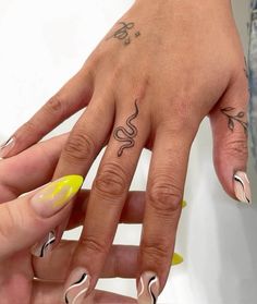 two hands with different designs on them and one has a yellow nail polish vare