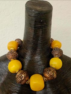 This stunning homage to Iris Apfel is from my private collection and is new and unworn. Five big, bold and chunky predominantly yellow (with a tinge of orange) Copal Amber beads are alternated with huge and ornate Tibetan Copper Repousse Beads. Each copal bead ranges in size from the smallest at 1.5" to the largest at 1.75". I did the water floatation test on these beads and they did indeed float! Separating all the large beads is a pair of burnished gold tone metal wavy potato chip spacers. Thi Yellow Beaded Necklaces With Large Beads For Festivals, Yellow Beaded Necklace With Large Beads For Festivals, Traditional Yellow Gemstone Beads Necklace, Artisan Necklace With Large Beads For Rituals, Large Yellow Beads For Festivals, Yellow Large Beads For Festivals, Artisan Yellow Beaded Necklaces For Festivals, Artisan Yellow Necklaces With Wooden Beads, Artisan Yellow Beads For Festivals