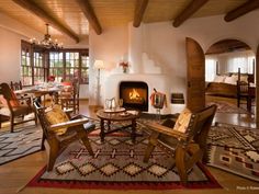 a living room filled with furniture and a fire place in the middle of a room