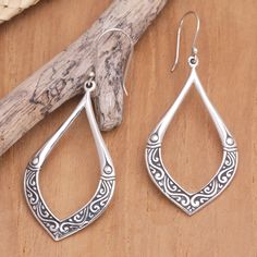 Traditional Balinese motifs enhance the beauty of these sterling silver dangle earrings by Dewa Arimbawa. With leafy formations, the accessory features a luminous appearance, making it an exquisite creation full of culture. Ornate Sterling Silver Teardrop Earrings As Gift, Ornate Sterling Silver Teardrop Earrings For Gift, Sterling Silver Intricate Teardrop Earrings, Sterling Silver Teardrop Earrings With Intricate Design, Bohemian Sterling Silver Teardrop Earrings With Intricate Design, Ornate Sterling Silver Teardrop Earrings, Sterling Silver Teardrop Earrings With Oxidized Finish, Elegant Oxidized Finish Teardrop Dangle Earrings, Trendy Silver Jewelry