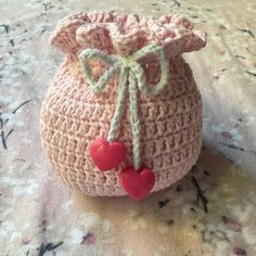 a small crocheted bag with two hearts on the front and one in the back