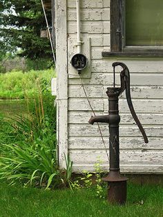 an old water faucet sitting in front of a house