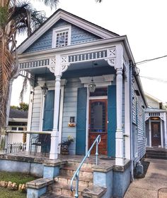 a blue and white house with steps leading up to the front door