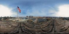 the american flag is flying high in the sky over an industrial area with many fences