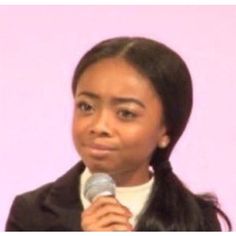 a woman holding a microphone in front of a pink background with the words, how do you know what this girl is?