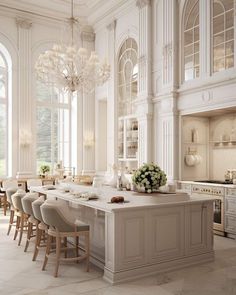 a large kitchen with an island and lots of chairs around the counter top, along with many windows