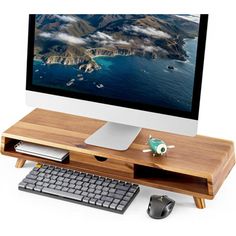 a computer monitor sitting on top of a wooden desk next to a keyboard and mouse