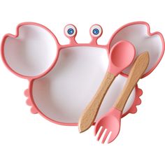 a pink plate with two spoons and a wooden fork on it, shaped like a mouse