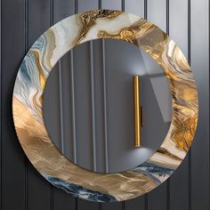 a circular mirror hanging on the side of a wall next to a gold door handle