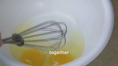 two eggs being whisked together in a white bowl with the words together on it