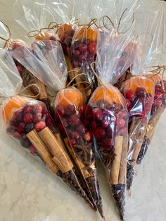 there are many fruits wrapped in plastic bags on the counter top, including cranberries and oranges