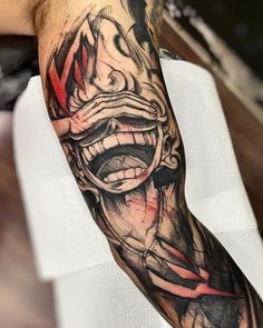 a man with a tattoo on his arm has a creepy face and red lines coming out of it