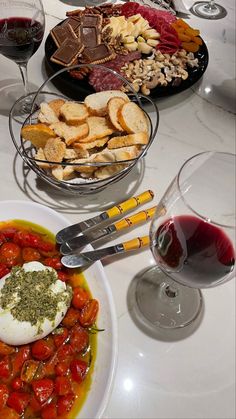 a table topped with plates of food and glasses of wine