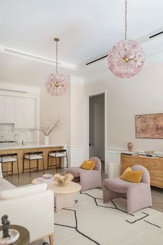 a living room filled with furniture and a chandelier hanging over the top of it