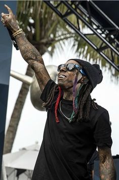 a man with dreadlocks on his head and sunglasses is standing in front of a stage